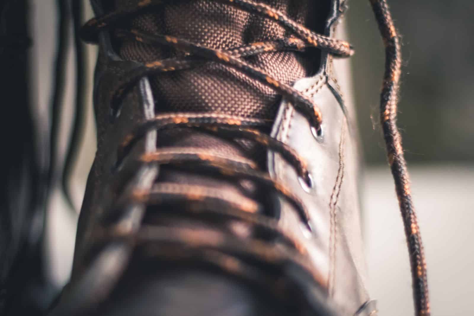 Close-up of a brown leather lace-up boot showing stitching and texture